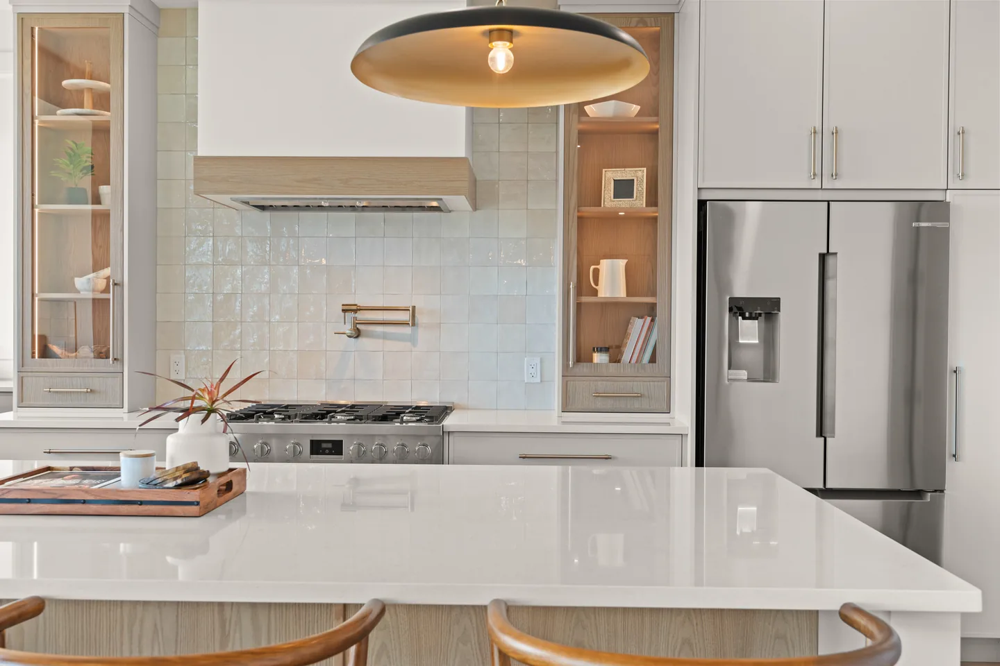 Tiled range wall with pot filler and glass-front cabinets